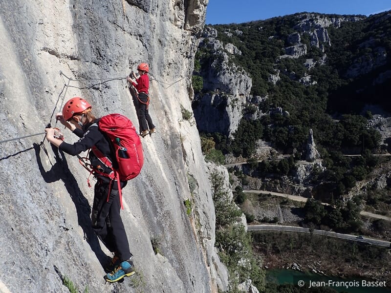 Groupe de personne pratiquant la via ferrata sur une falaise